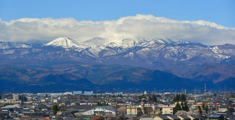 Fototapeta premium Cityscape with snow mountain in sunny day