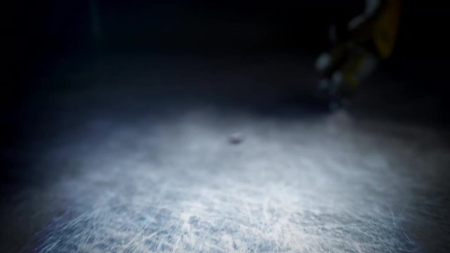 Hockey player in yellow uniform hits the puck in slow motion