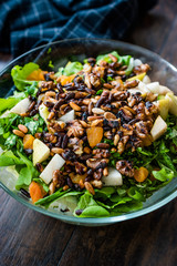Pine Nut Salad with Walnut, Pear, Dried Apricot, Arugula or Rucola Leaves in Glass Bowl.