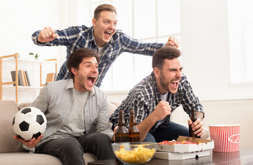 Excited friends watching football match and shouting