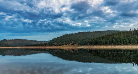 Mountain lake with fog and colorful sky, springtime 