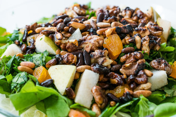 Pine Nut Salad with Walnut, Pear, Dried Apricot, Arugula or Rucola Leaves in Glass Bowl.