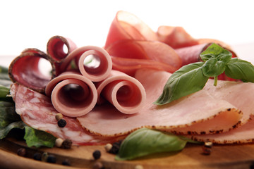 Food tray with delicious salami, pieces of sliced ham, sausages,salad and vegetable. Meat platter with selection