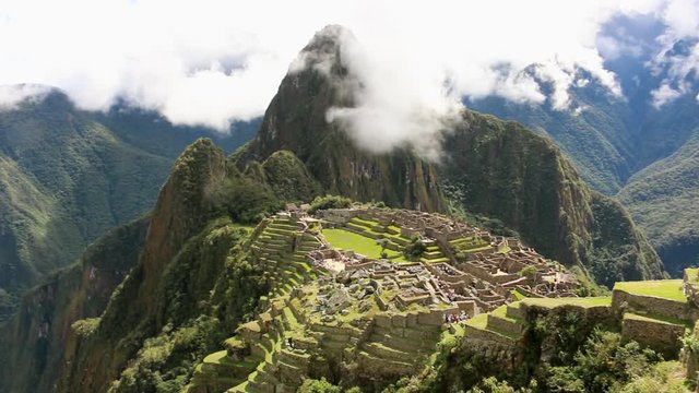 Shot panning throughout Machu Picchu and over the ancient ruins with various tourists walking around 