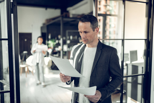 Mature Serious Businessman Reading Some Report And Documents