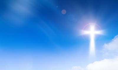 Holy light of crucifix cross on blue sky background. Hope and freedom concept.