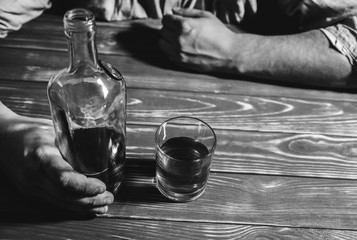 Alcoholic addict. Man holding with alcohol and a glass. Dangerous habit. Unhealthy life concept. Social problem.