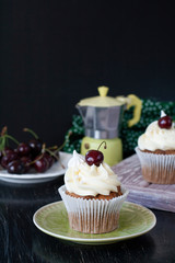 A tasty treat: frosted cupcakes with cherries on top.