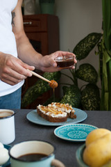 A tasty breakfast fowr two: rye bread sandwiches, fresh fruits, honey and coffee.