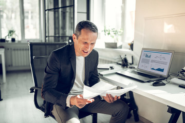 Businessman feeling angry while working on financial report