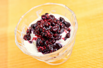 Ice cream dessert with currant jam on yellow table-napkin. Selective focus