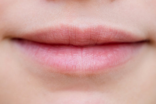 Part of face, young woman lips close up. Plump lips without makeup