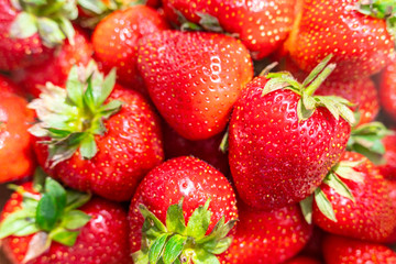 Fresh beautiful strawberries in wooden bowl top view. Strawberry fruits on wooden table copy space.