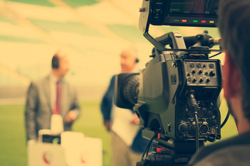 TV camera for broadcast hockey. Professional cameraman - covering an event to a live and record...