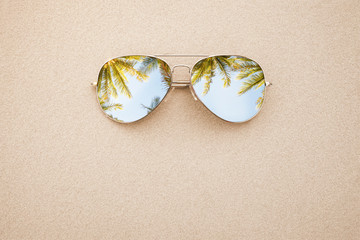 Summer concept, sunglasses in the sand, on the beach with copy space