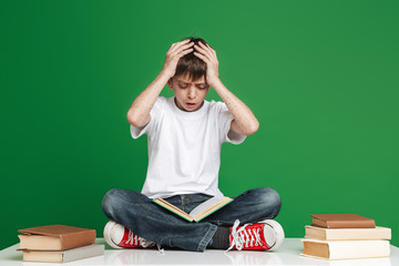 Shocked young boy with freckles reading book
