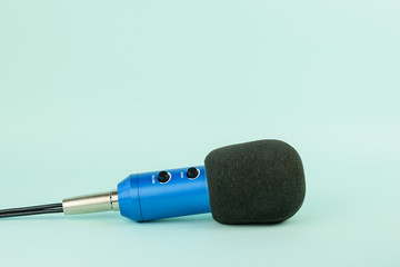 The blue microphone with the connected wire on a blue background.