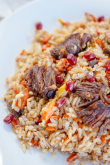 Traditional asian and oriental pilaf or plov with meat on the white plate.