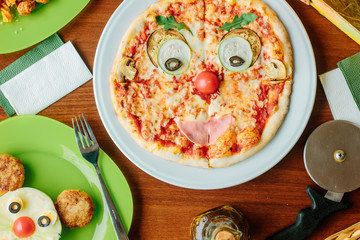 Top view of pizza for kids in a form of funny face.