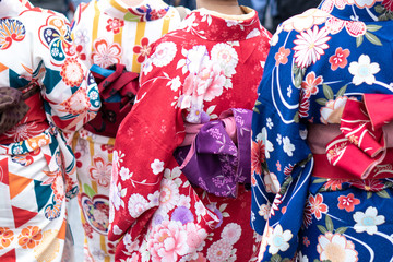 Fototapeta premium Young girl wearing Japanese kimono standing in front of Sensoji Temple in Tokyo, Japan. Kimono is a Japanese traditional garment. The word 