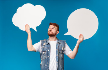 Young man having complex choice between two speech bubbles