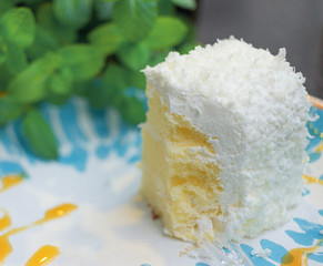 Small white mousse cake, blue and white plates and green mint leaves