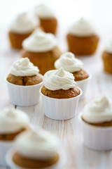 Carrot cupcakes with vanilla frosting. White wooden table, high resolution