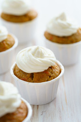 Carrot cupcakes with vanilla frosting. White wooden table, high resolution