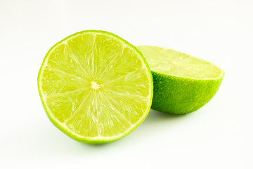 Lime cut in two halves of green color on white background