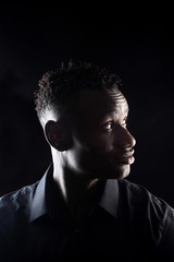portrait of a african man on black background,profile
