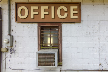 Large office sign on side of forgotten and abandoned building