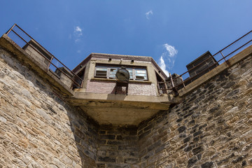 Fototapeta na wymiar Guard tower of an old stone block prison left empty