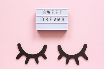 Lightbox text Sweet dreams and decorative wooden black eyelashes, closed eyes on pink paper...