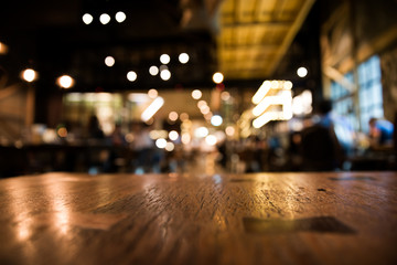 Real wood table and waitress with light reflection on scene at restaurant, pub or bar at night. Blurred background for product display or montage your products with several concept idea.