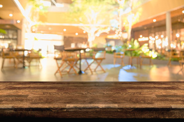 Empty wood table top and blur of night pub or restaurant background/selective focus .For montage product display