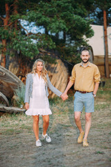 Fototapeta premium A happy young couple walking by nature, a pregnant girl, a bearded man. Love. The concept of pregnancy