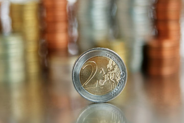 European Union bimetallic coin worth 2 Euros on a background of stacks of coins