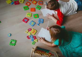 little boy and girl learn to write and calculate numbers
