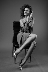 Young beautiful woman with curly hair posing in black and white