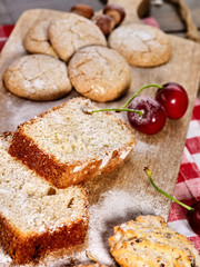 Oatmeal cookies and cherry on kitchen cutting board gingham checkered cotton fabric on table in village style for picnic. New dishes in expensive cafe. Preparatory work before cooking courses.
