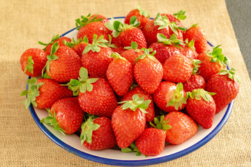 Plate of strawberries on textile background