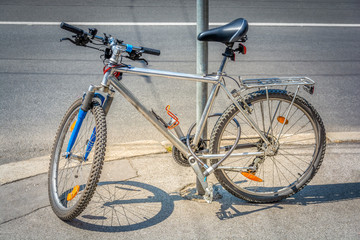 Naklejka premium The bike parked next to the pole and secure with locking device on the streets