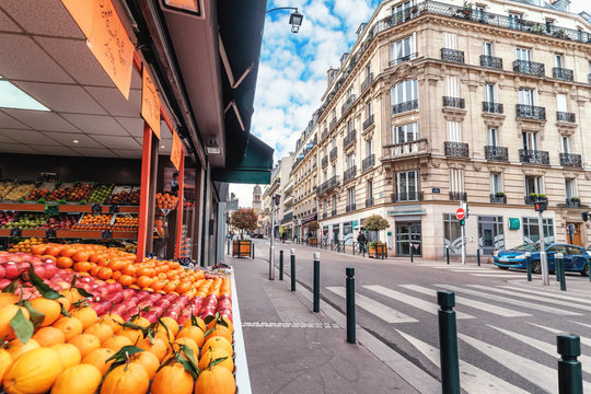 Fototapeta Streets of Paris, France. Blue sky, buildings, traffic and street fruit market.