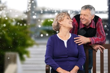 Close-up portrait of an elderly couple hugging in park