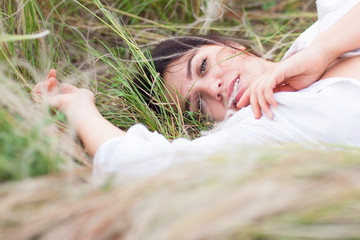 young beautiful woman lying on the grass enjoying rest
