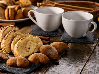 Cookies heart shape, sand rolled biscuit and cinnamon stick on wood table served dessert spoon at kitchen in rustic style. Morning sun flare. Problems with excess weight.