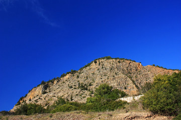 Shrubs on the slope of a stone hill