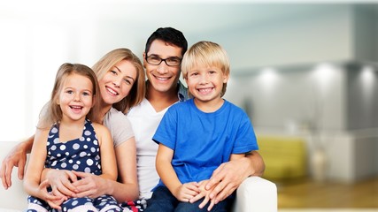 Young family at home smiling at camera