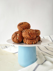 Cookies from whole wheat flour with Chia seeds and sunflower seeds in a dish on a blue leg on a white background close-up. The concept of proper nutrition.