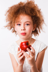 Curly mom and daughter eat big red apples on a light background.